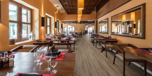 Cafe restaurant interior with wooden furniture lighting equipment and decoration.